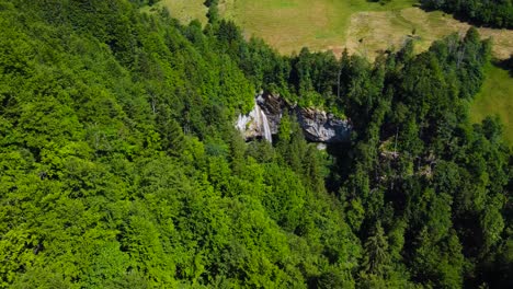 Stunning-Aerial-Shot-of-Berglistüber-Waterfall-in-Thick-Forest-in-Switzerland