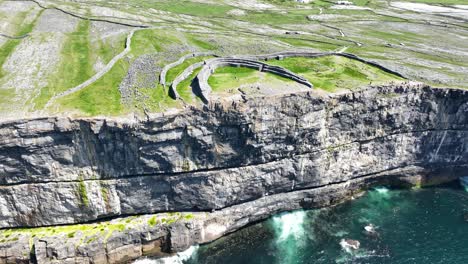 Drone-Circling-Dun-Angus-Fort-Aran-Islands-Ireland-perilous-perched-on-a-sheer-sea-cliff-on-the-Atlantic-Ocean,the-largest-of-the-prehistoric-stone-forts-on-the-Aran-Islands