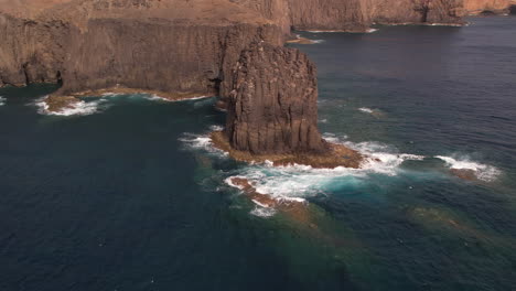 Roque-Partido,-Gran-Canaria:-aerial-and-zoom-out-view-of-the-rock-formation-called-Roque-Partido-on-the-island-of-Gran-Canaria-and-on-a-sunny-day