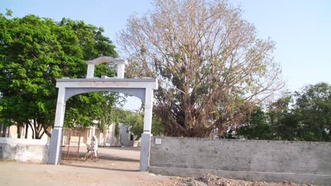 A-scene-from-an-Indian-village-showing-the-village-gate-and-a-man-riding-a-bicycle