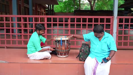 Südindische-Musiker-Verwenden-Einen-Schraubenschlüssel,-Während-Sie-Das-Thavil-Am-Tempel-Justieren