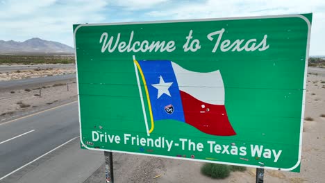 Rising-aerial-of-Welcome-to-Texas-sign-with-state-flag