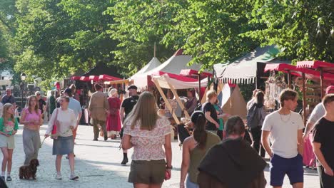 People-walking-by-the-market-booths-on-a-sunny-summer-evening