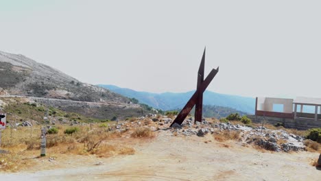 Eine-Niedrige-Und-Nahe-Drohnenaufnahme-Eines-Zufälligen-Eisendenkmals-Entlang-Der-Nationalstraße-In-Andalusien,-Spanien