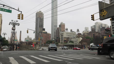 Paso-De-Peatones-De-La-Ciudad-De-Nueva-York-En-Hora-Punta-Con-Tráfico,-Peatones-Y-Teleférico