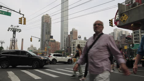 Menschen-überqueren-Eine-Straße-In-New-York,-Während-Die-Straßenbahn-Von-Roosevelt-Island-über-Ihnen-Vorbeifährt