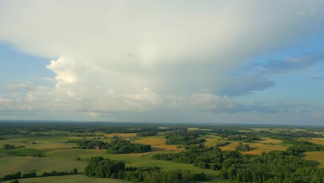 Luftaufnahme-Einer-Flachen-Landschaft-Mit-Fruchtbaren-Feldern,-über-Denen-Sich-Riesige-Wolken-Bilden