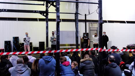 CrossFit-Competition-Briefing:-Coaches-Presenting-Program-on-Whiteboard-to-Seated-Athletes