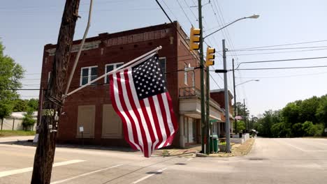 Downtown-Pine-Hill,-Alabama-with-American-flag-flying-in-the-wind-in-slow-motion