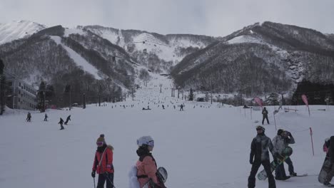 Das-Kameraobjektiv-Fängt-Die-Lebhafte-Szene-Des-Hakuba-Skigebiets-Bei-Tageslicht-Ein,-Während-Begeisterte-Skifahrer-Anmutig-Die-Gut-Präparierten-Pisten-Hinuntergleiten