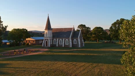 Adaminaby,-New-South-Wales,-Australia---30-December-2018:-Rising-up-behind-a-tree-to-reveal-the-St-John's-Church-in-Adaminaby-in-the-Snowy-Mountains