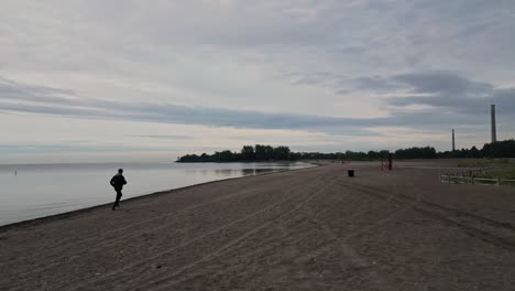 Man-Running-At-Woodbine-Beach-In-Toronto,-Ontario-At-Sunrise