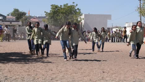 slow-motion-scene-in-which-young-girls-from-an-Indian-government-primary-school-are-playing-a-game-of-walking-on-one-leg-is-shot-from-the-front