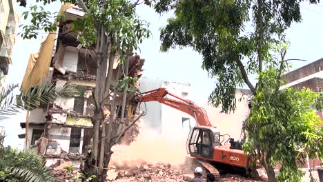 Escena-Urbana-Con-Hombres-Mirando-La-Excavadora-Demoliendo-Un-Pequeño-Edificio