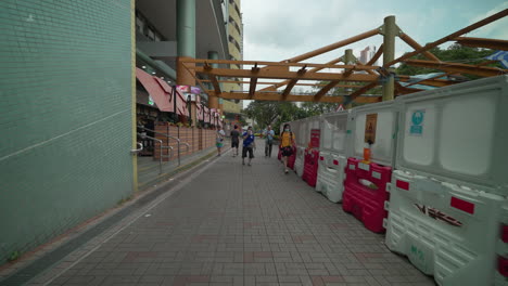 Pov-walk-on-walkway-in-City-of-Hong-Kong-beside-The-ONE-Market-Shopping-Center-during-cloudy-day