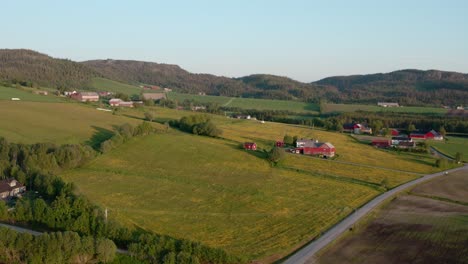 Aerial-View-Of-Countryside-With-Fields,-Houses-And-Mountain-Range-At-Dusk