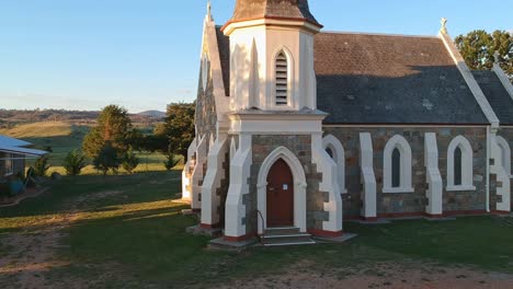 Adaminaby,-New-South-Wales,-Australia---30-December-2018:-Rising-over-St-John's-Anglican-Community-Church-in-Adaminaby-revealing-sunlit-hills-beyond