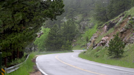 Radfahrer-Und-Auto-Fahren-Bei-Strömendem-Regen-Auf-Gebirgspass,-Felsbrockenlandschaft