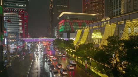 Toma-Aérea-De-Retroceso-De-Carreteras-Transitadas-En-Un-Día-Lluvioso-En-La-Ciudad-De-Taipei-En-El-Centro-De-La-Ciudad-Por-La-Noche---Temporada-Navideña-Con-Muchas-Cadenas-De-Luces-Decoradas-En-Edificios-Y-árboles