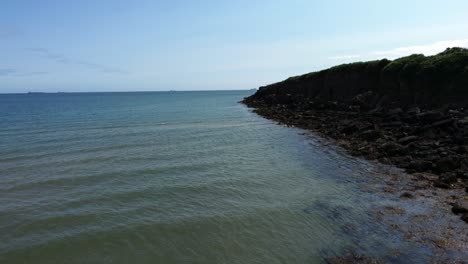 Aerial-view-Traeth-Lligwy-Jurassic-rocky-weathered-Anglesey-beach-with-dog-walkers-chatting