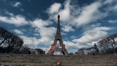 Eiffel-Tower-with-moving-clouds,-Landmark-in-Paris-with-Champ-de-Mars,-A-Romantic-Capital-in-Sunny-Day,-Dramatic-clouds-at-afternoon-magnificent-sky-in-fast-motion