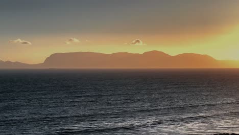 Horizont-Im-Golf-Von-Oman,-Insel-Bei-Sonnenuntergang-Im-Ozean,-Verschwommener-Himmel-Und-Berge-Im-Hintergrund,-Kamera-Bewegt-Sich-Vorwärts-Und-Zeigt-Eine-Wunderschöne-Insel-In-Der-Welt