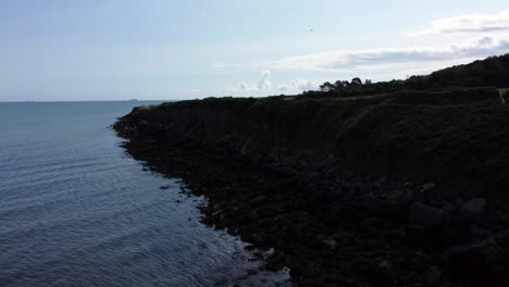 Aerial-view-Traeth-Lligwy-Jurassic-rocky-weathered-Anglesey-coastal-shoreline,-slow-push-in