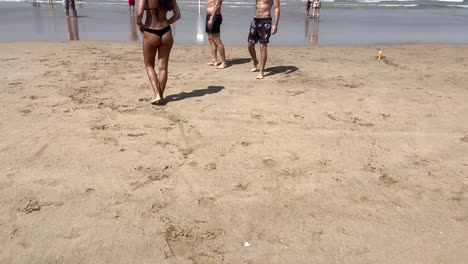 fit-woman-with-black-bikini-walking-in-yellow-on-Caparica-beach-in-Portugal