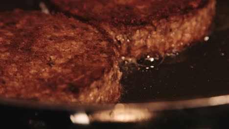 Close-Up-of-PlantBased-Imitation-Burgers-Frying-in-Hot-Pan-with-Camera-Pulling-Focus
