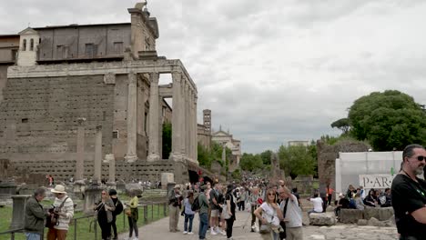 Turistas-A-Lo-Largo-De-Via-Della-Salara-Vecchia-Con-Vistas-Al-Templo-De-Antoninus-Y-Faustina-En-El-Foro-Romano-En-Un-Día-Nublado