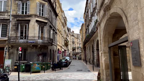 Pov-dolly-walk-on-historical-street-with-old-buildings-in-Bordeaux-during-sunny-day,-France---Slow-motion