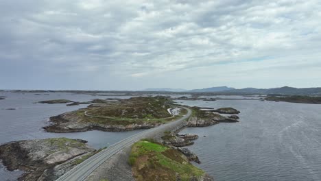 Aerial-along-the-famous-Atlantic-Ocean-Road-in-Norway---Low-altitude-aerial-crossing-over-road-and-looking-north-in-coastal-landscape