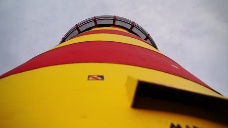 Small-red-and-yellow-lighthouse-in-Pilsumer
