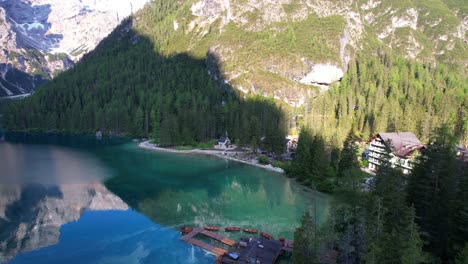 Aerial-shot-over-Lago-di-Braies-and-its-wooden-pier-revealing-a-II-World-War-church