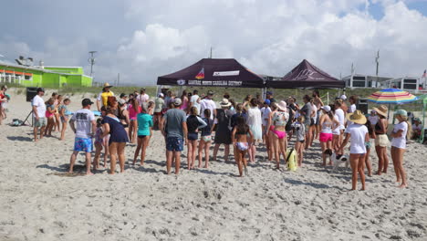 Tents-set-up-at-a-surfing-event-or-competition-with-people-gathered-around