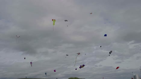 Many-colourful-kites-being-flown-high-in-the-sky,-slow-motion-footage