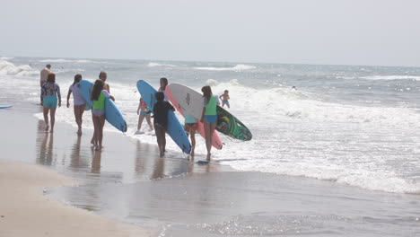 Junge-Mädchen-Gehen-Mit-Surfbrettern-In-Die-Brandung