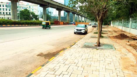 Traffic-Along-a-Dusty-Sidewalk-in-India-with-Urban-Trees