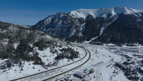 Drone-aerial-Copper-Mountain-Woodward-winter-ski-snowboard-resort-half-pipe-training-Colorado-crisp-cold-early-morning-fresh-snow-i25-car-traffic-highway-lodging-cinematic-forward-pan-up-motion-4k