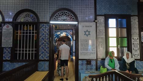 Turistas-En-La-Sinagoga-Judía-El-Ghriba-De-Djerba-En-Túnez-En-La-Temporada-De-Verano-Con-El-Símbolo-De-La-Estrella-Judía-De-David-En-La-Pared