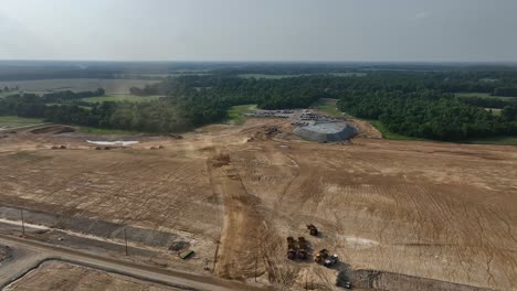 4K-Aerial-approach-of-dirt-moving-equipment-at-BlueOval-City-in-Stanton,-TN