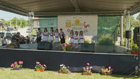 Niños-Pequeños-Vestidos-De-Búlgaro-Actúan-En-El-Escenario-Del-Festival-De-Verano