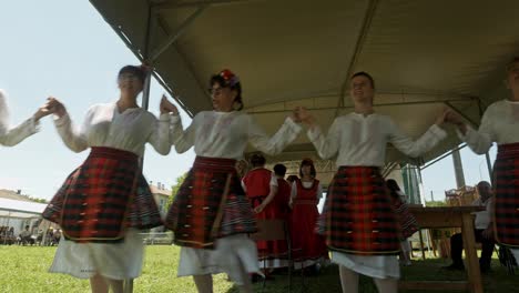 Happy-People-dance-Bulgarian-horo-under-shaded-tent-at-summer-festival