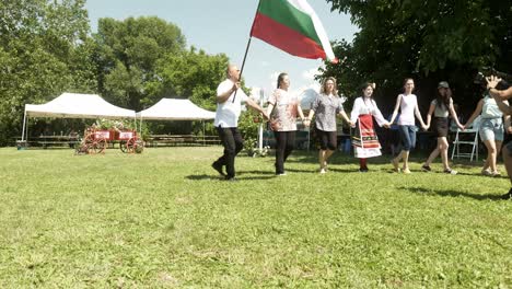 Dorfbürgermeister-Schwenkt-Nationalflagge-Und-Tanzt-Mit-Menschenmenge-Bei-Kultureller-Veranstaltung
