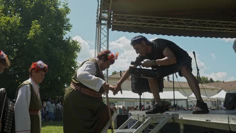 El-Camarógrafo-Ayuda-A-Mujeres-Mayores-A-Subir-Al-Escenario-Del-Festival-En-Un-Evento-Cultural-Búlgaro