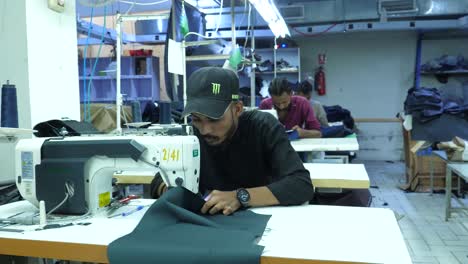 Trabajador-Textil-Masculino-Paquistaní-Usando-Una-Máquina-De-Coser-Dentro-De-La-Fábrica