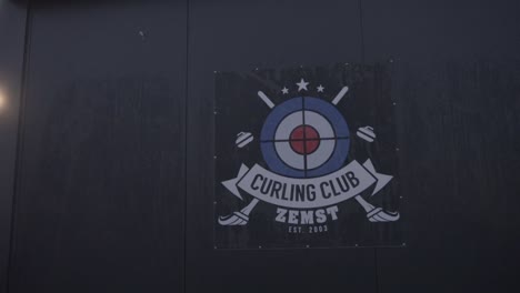 Logo-Des-Curlingclubs-Zemst-Auf-Einem-Gebäude-Mit-Sonnenschein-Flair
