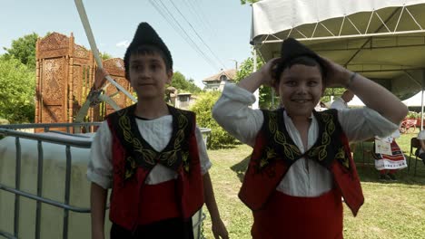 Zwei-Glücklich-Lächelnde-Jungen-In-Traditioneller-Bulgarischer-Kleidung-Und-Kalpak-Hüten