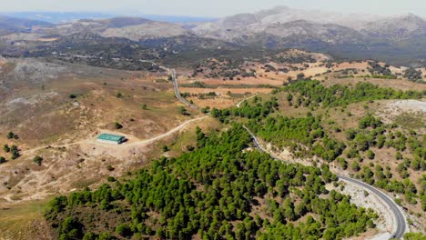 Drohnenschuss,-Der-Von-Den-Hügeln-Und-Der-Landschaft-In-Andalusien-Auf-Die-Straße-Kippt