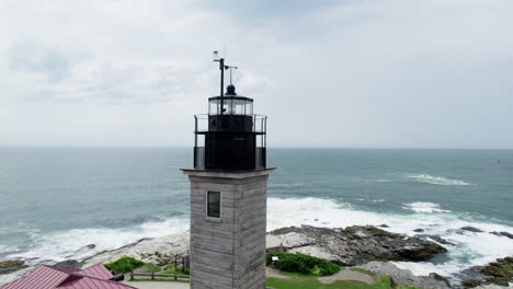 Aerial-tour-around-the-tower-of-Beavertail-Lighthouse,-Rhode-Island